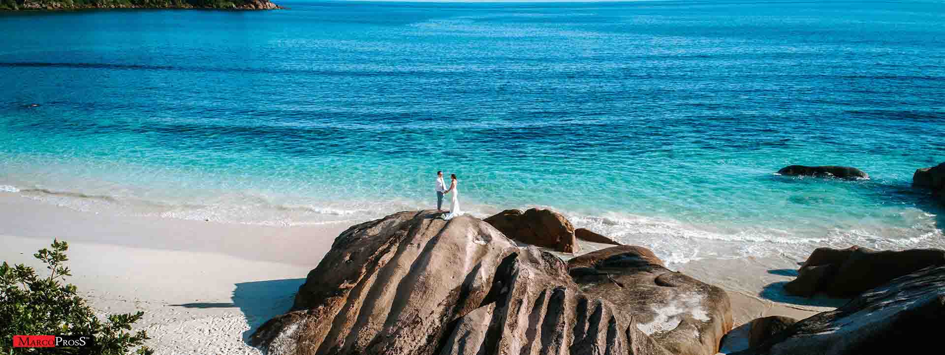 wedding in seyschelles - couple on a big beach stone on Mahe island